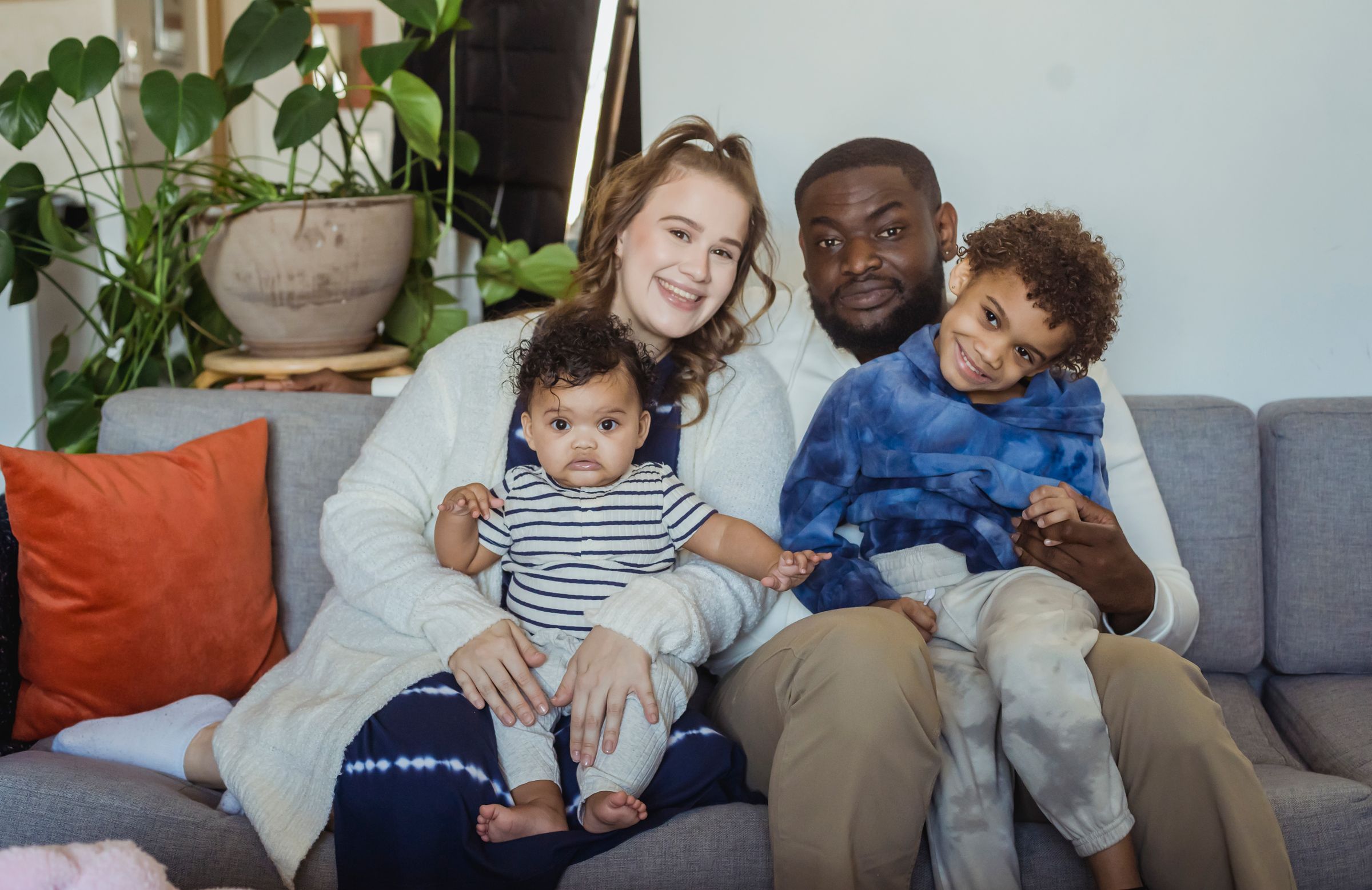 Mara and Theo seated at home with their two children